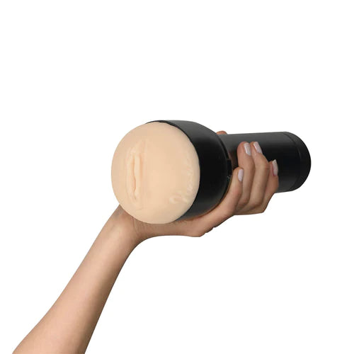 Masturbador masculino Feel Nicolette by Kiiroo sostenido en una mano, mostrando su funda realista con apertura vaginal y carcasa negra.