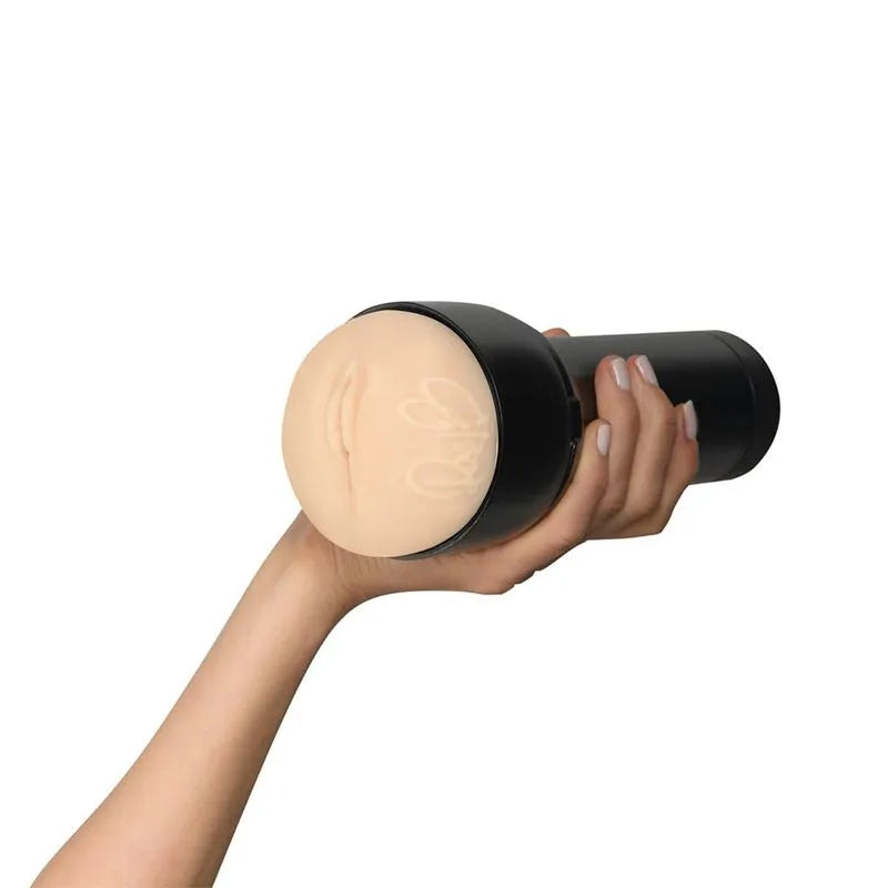 Masturbador Feel Rae Lil Black by Kiiroo sostenido en una mano, mostrando la funda con firma y diseño exclusivo.