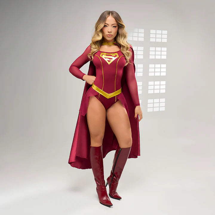 Mujer usando el disfraz Chica de Acero de color vinotinto con capa larga y detalles dorados, botas altas y actitud poderosa, ideal para fiestas o cosplay.