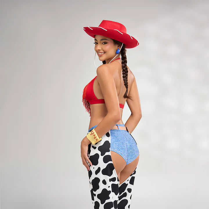 Mujer usando disfraz Miss Rodeo visto desde atrás, con sombrero rojo, top rojo con flecos, short tipo denim y chaparreras estampadas en print de vaca, destacando un estilo vaquero sensual.